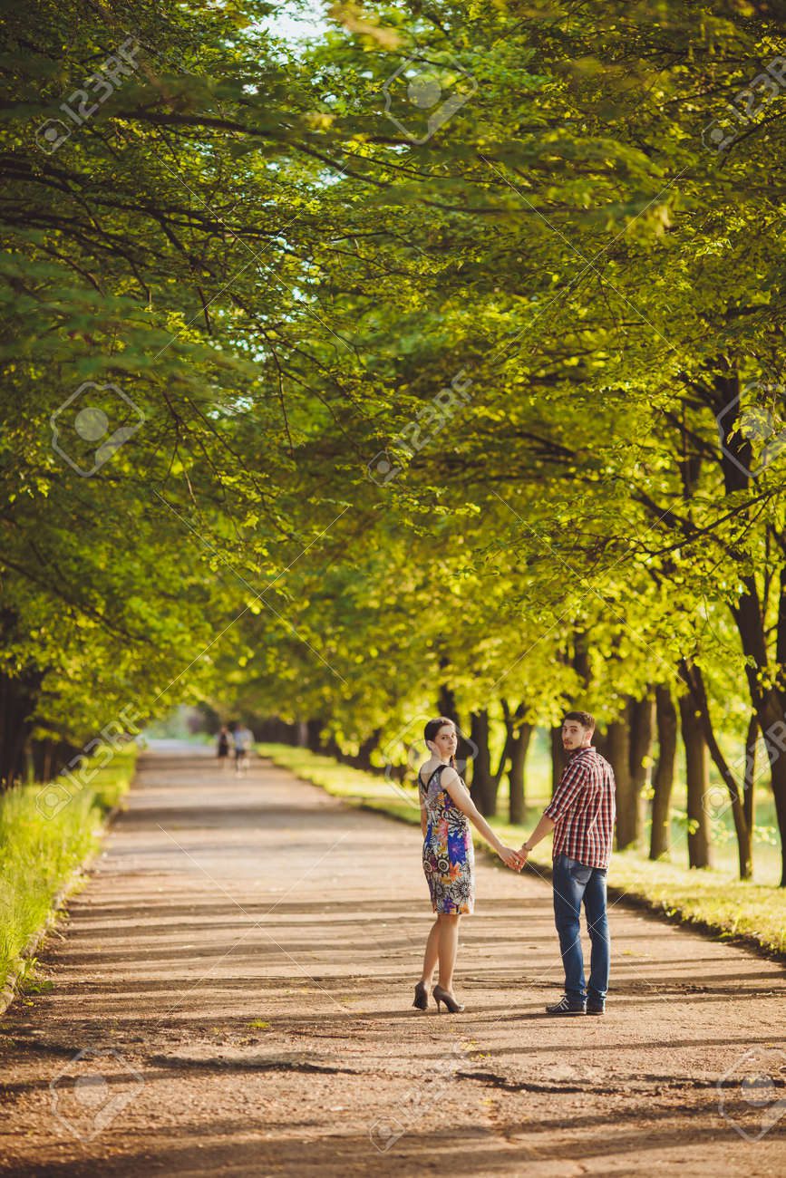 Pareja caminando de la mano en parque