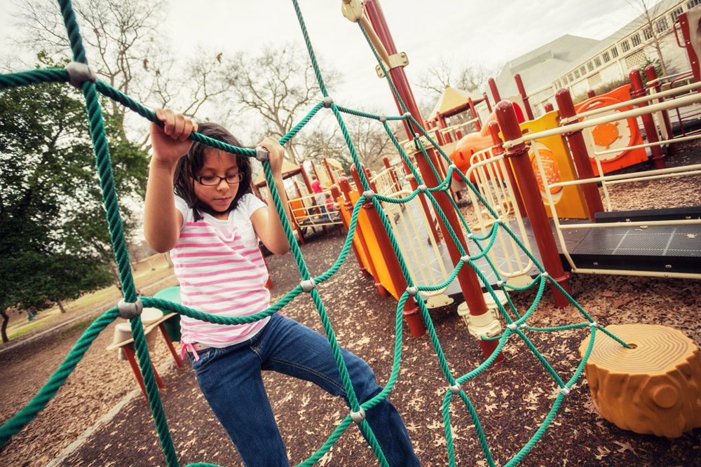 Niños jugando en parque infantil seguro