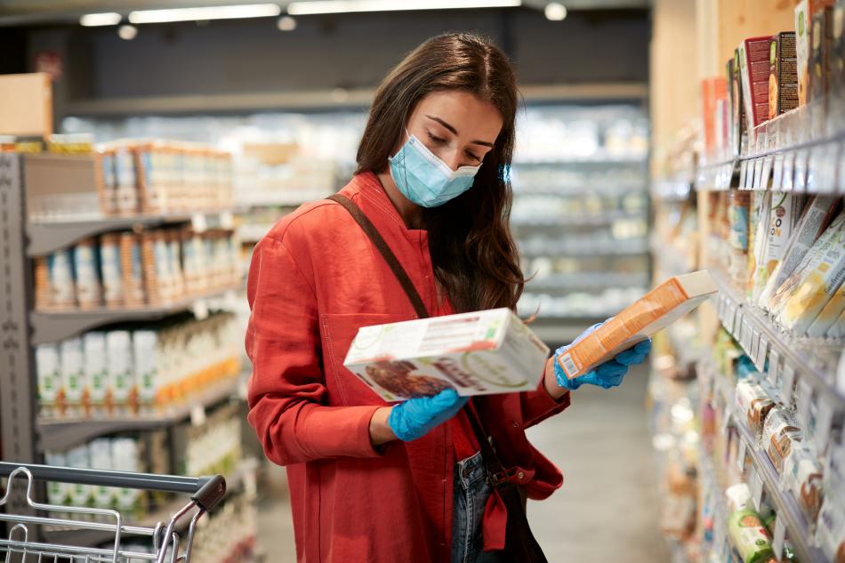 Persona comprando alimentos sin nitrosaminas en supermercado