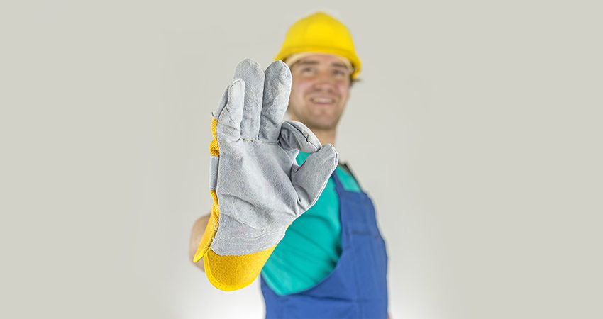 Hombre usando guantes industriales en fábrica