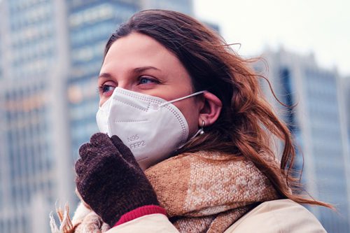 Mujer mostrando cómo usar una mascarilla correctamente