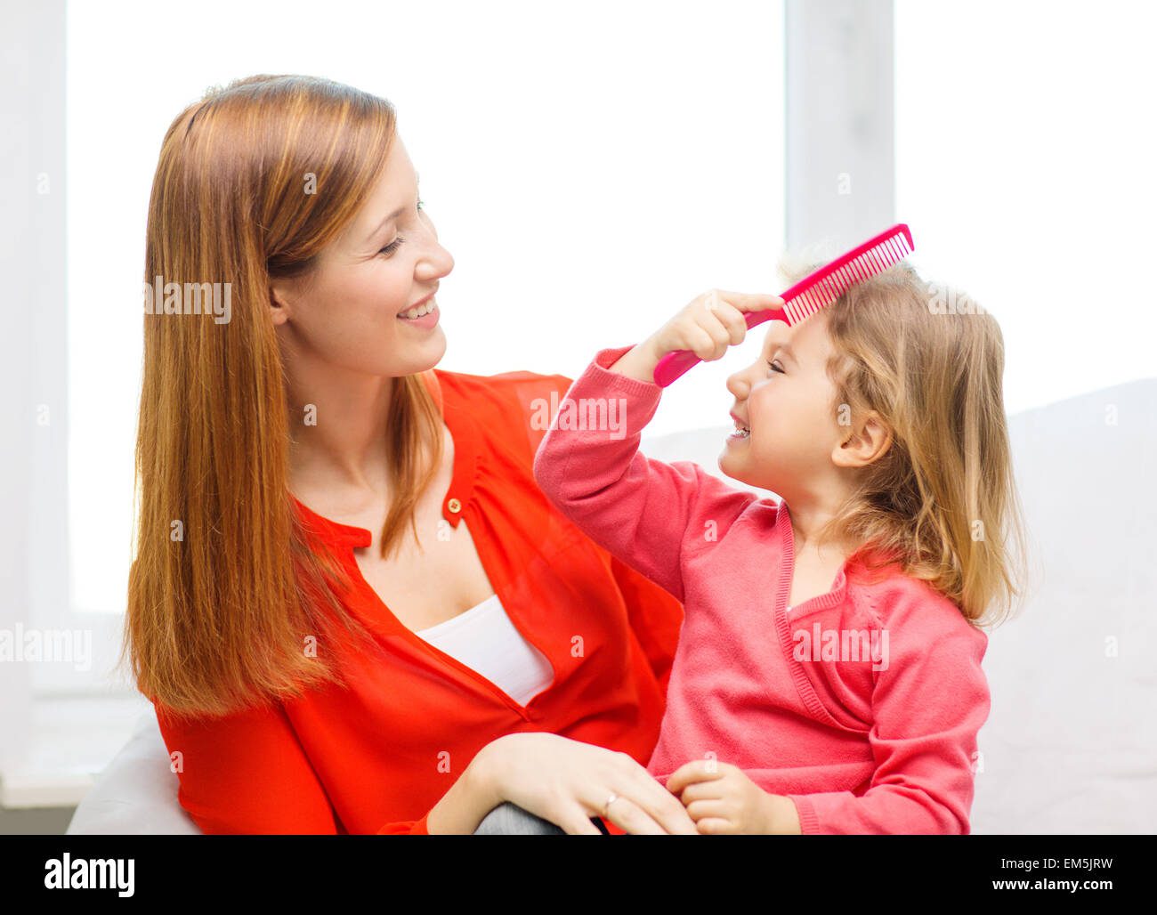 Madre revisando cabello de niña con peine