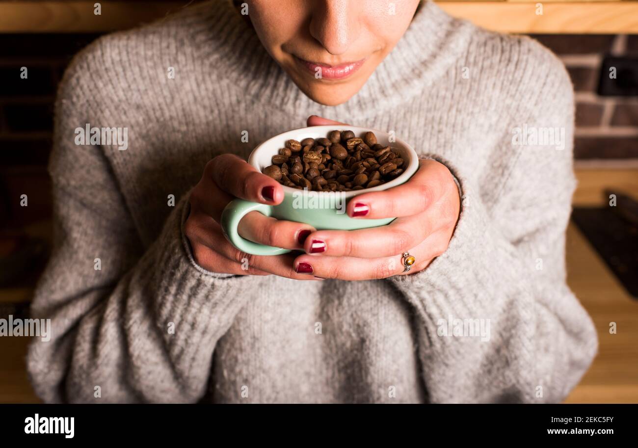 Persona oliendo y probando frijoles frescos